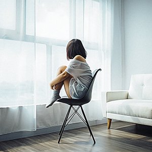 young alone girl looking out window